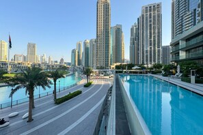 Un entorno urbano moderno con piscina, palmeras y edificios altos.