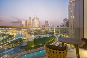A balcony with a view of a cityscape, including high-rise buildings and a river. - Majestic 2 BDR with Burj Khalifa and Fountain View (Dubai)