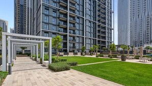 En modern bostadsbyggnad med en central innergård, omgiven av höga hyreshus.