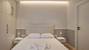 A neatly arranged bedroom with a large bed, two bedside tables, and a wardrobe. - Urban Allure in Athina (Athens)