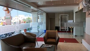 A modern lobby with leather sofas, a reception desk, and a 'Welcome' sign. - HOTEL RAMKRISHNA PALACE (Bijapur)