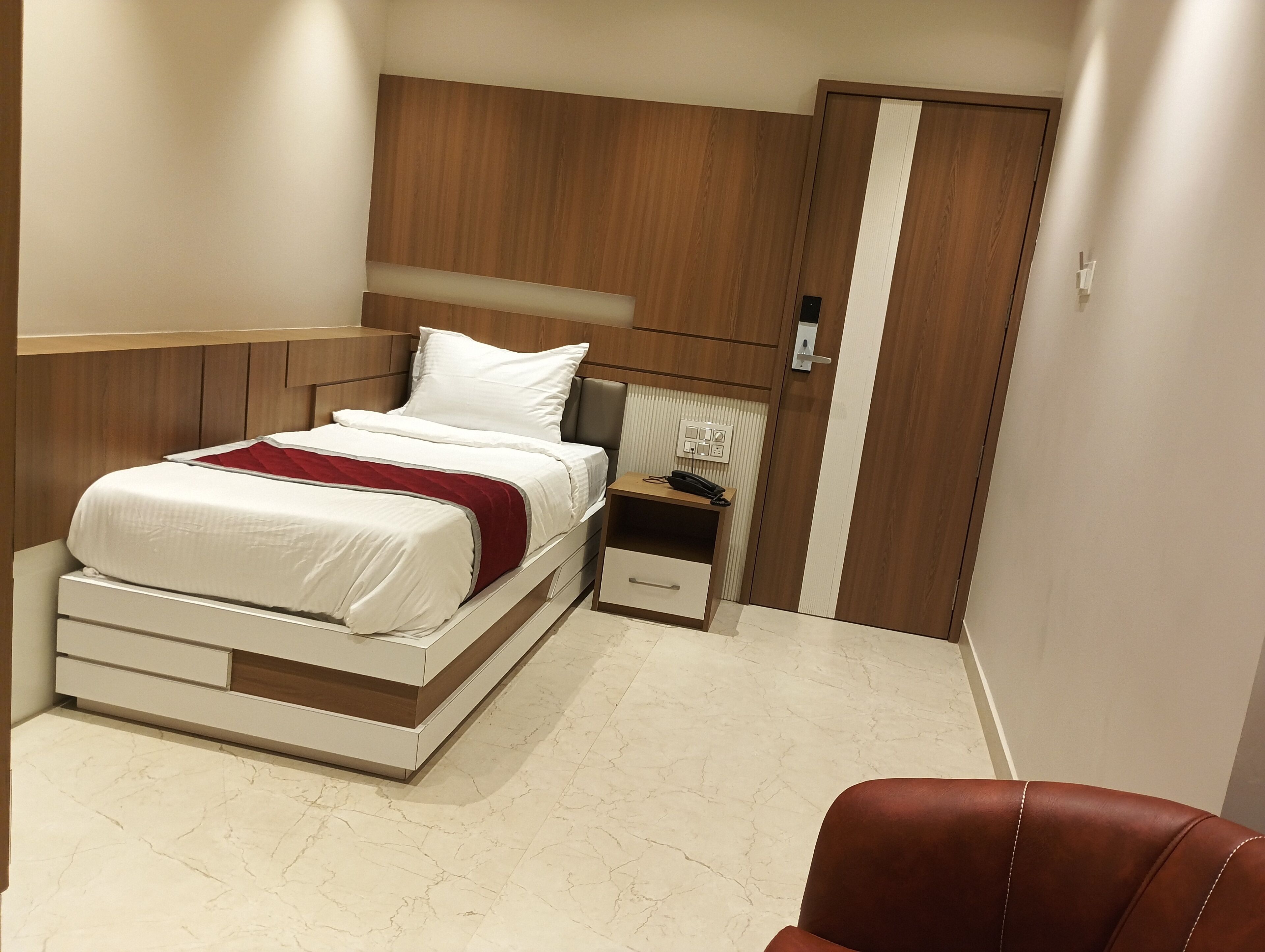 A bedroom with a bed, bedside table, and a wardrobe.