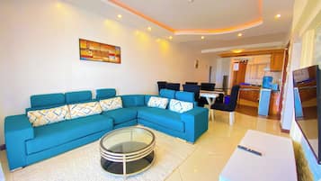 Deluxe Apartment, Partial Ocean View | Living area | Flat-screen TV