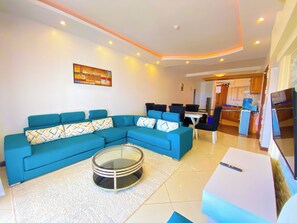 Deluxe Apartment, Partial Ocean View | Living area | Flat-screen TV - Mfalme Beachfront Apartments (Mombasa)