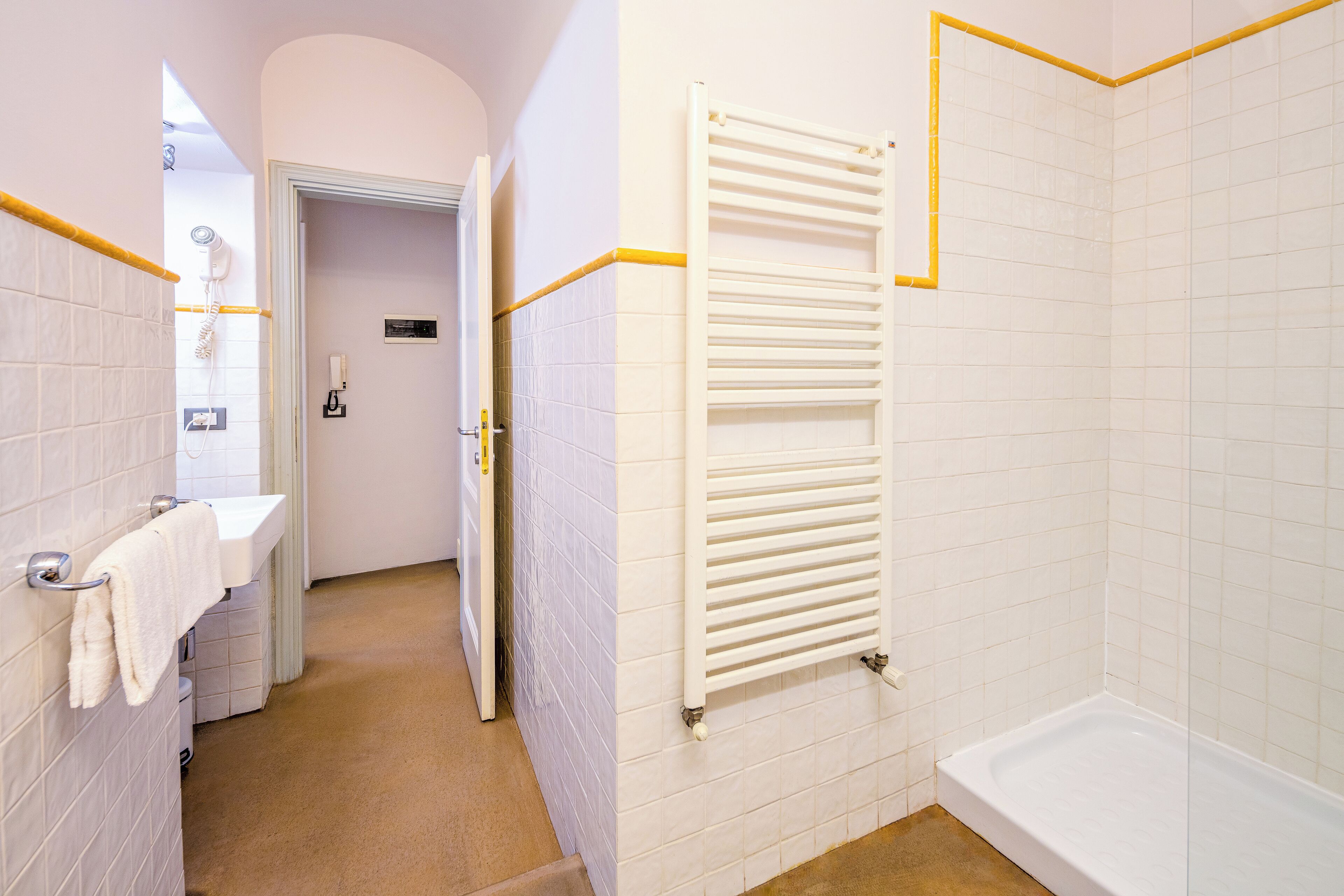 A bathroom with a white bathtub, a towel rack, and a shower area.