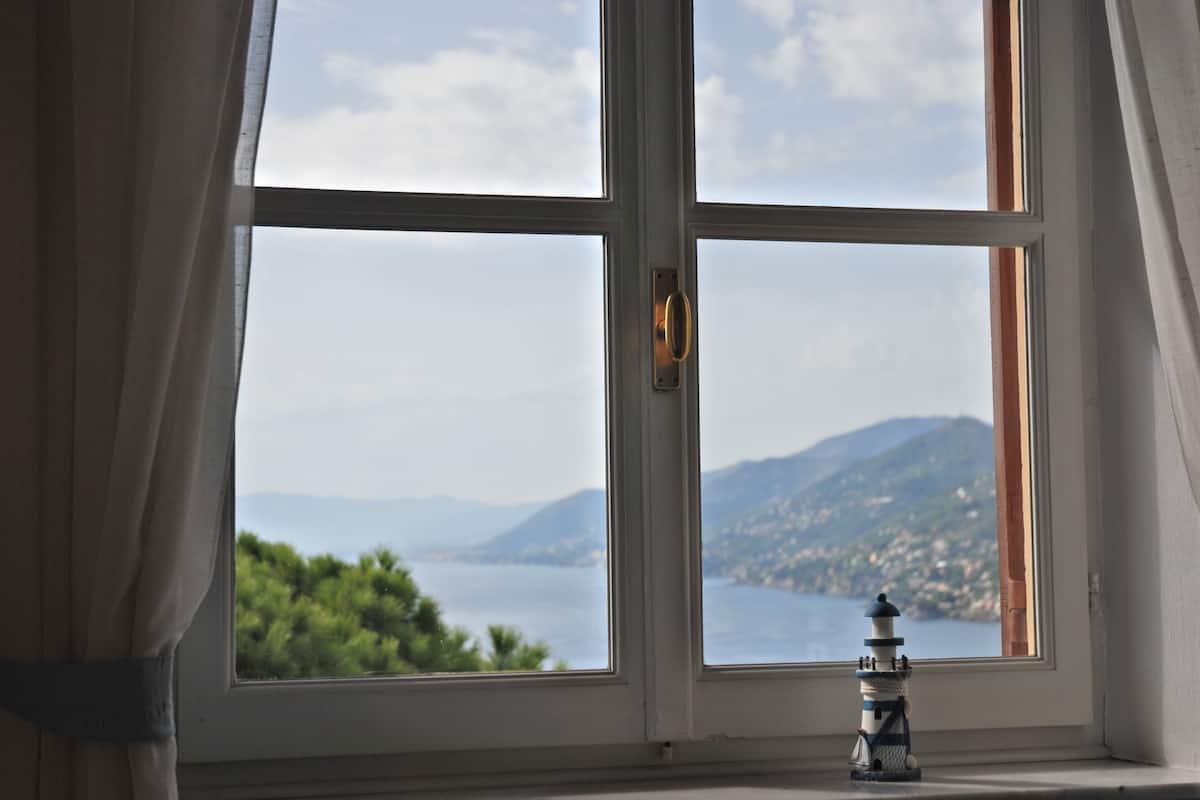 A window with a view of a body of water and mountains.