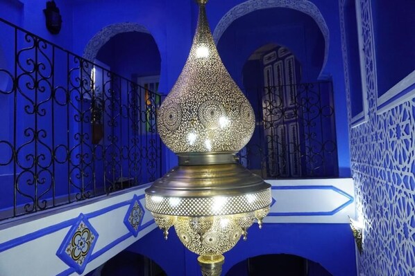 A chandelier with intricate patterns, a blue and white color scheme, and decorative metal railings.