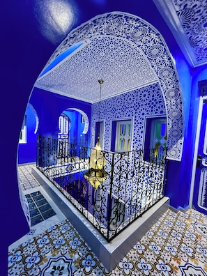 A room with intricate blue and white tile patterns, a decorative ceiling, and a patterned floor. - Riad Chengli (Chefchaouen)