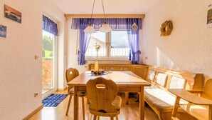 A dining area with a wooden table, chairs, and a bench. - Cozy Apartment in Marktrodach With Sauna (Marktrodach)