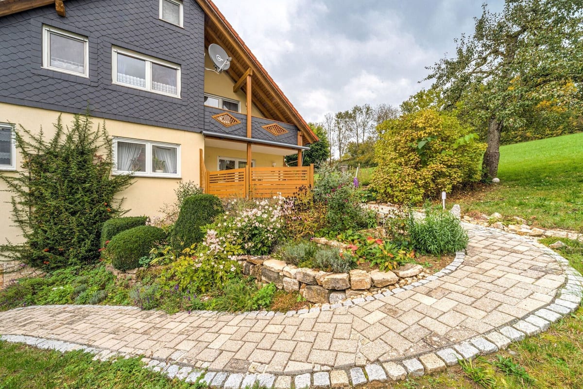 Ein zweistöckiges Haus mit einem Steinweg, der zur Eingangstür führt.