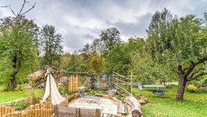 A rustic outdoor setting with a wooden deck, a hanging swing, and a small seating area. - Cozy Apartment in Marktrodach With Sauna (Marktrodach)