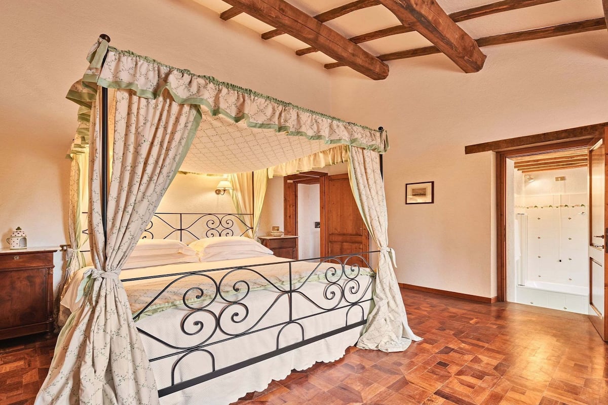 Un lit à baldaquin à quatre poteaux, avec un plafond et un plancher en bois.