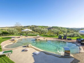 A pool area with lounge chairs, umbrellas, and a view of rolling hills. - Restful Holiday Home in Fermo With Swimming Pool (Fermo)