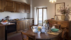 Una cocina con armarios de madera, una mesa de comedor con sillas y una ventana con vistas.