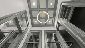A multi-level interior with a central skylight, multiple windows, and a circular light fixture.