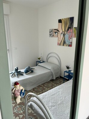 A bedroom with a bed, a nightstand, a wall clock, and a small potted plant. - Terrazza sul Mare (Marina Julia)