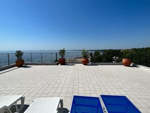 A terrace with tiled flooring, potted plants, and a view of the sea. - Terrazza sul Mare (Marina Julia)