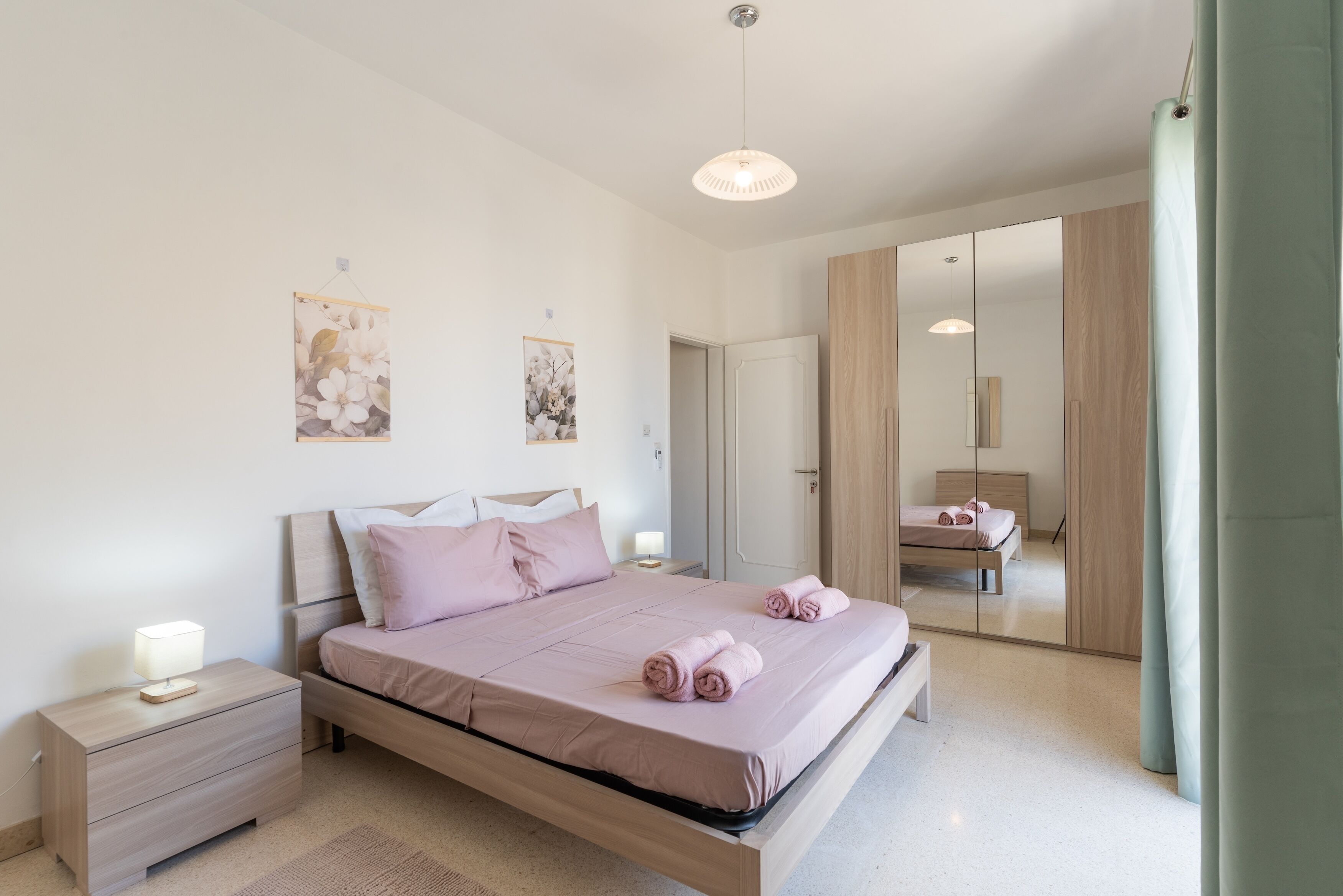 Un dormitorio moderno con cama, mesitas de noche y armario.