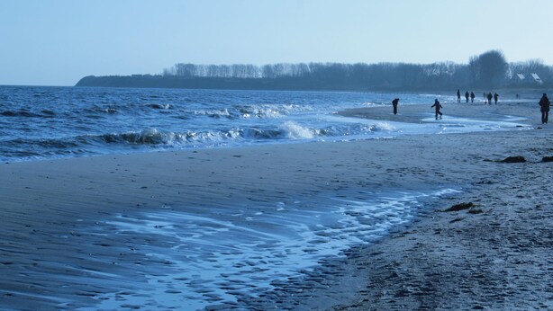 A beach with people walking and playing in the water. - Modern Holiday Home in Brusow With Roofed Terrace (Kroepelin)