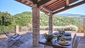 An outdoor dining area with a table set for two, surrounded by brick pillars and a pergola. - Picturesque Holiday Home in Assisi With Pool (Assisi)