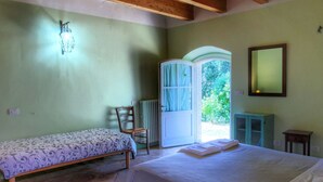 A bedroom with a bed, a chair, a small cabinet, and a mirror. - Picturesque Holiday Home in Assisi With Pool (Assisi)