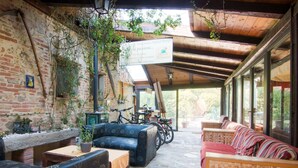 An outdoor seating area with brick walls, potted plants, and a wooden ceiling. - Holiday Home in Castiglione del With Pool (Castiglione del Lago)
