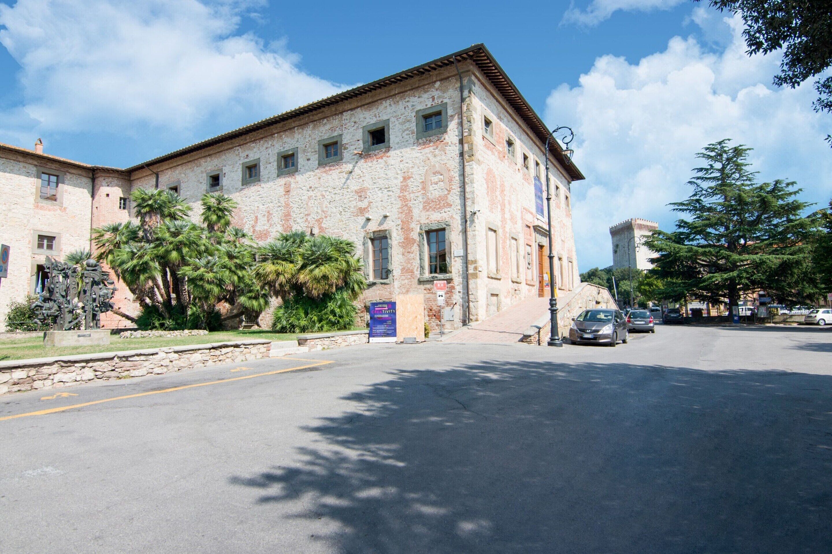 A historic building with a stone facade, multiple windows, and a tower.