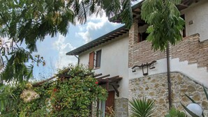 A rustic building with stone walls and a wooden balcony. - Country House With Swimming Pool and Garden With Mediterranean Plants (Bettona)