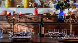 A dining table set with wine glasses and a bottle of wine, surrounded by decorative candle holders. - Countryside Villa in Amandola With Swimming Pool (Amandola)