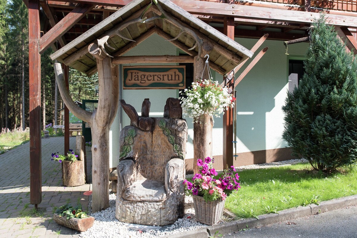 A wooden structure with a sign reading "Jägersruh" and a carved chair.