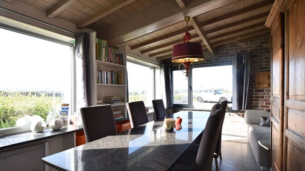 Un coin repas comprenant une table en granit, des chaises et une bibliothèque.