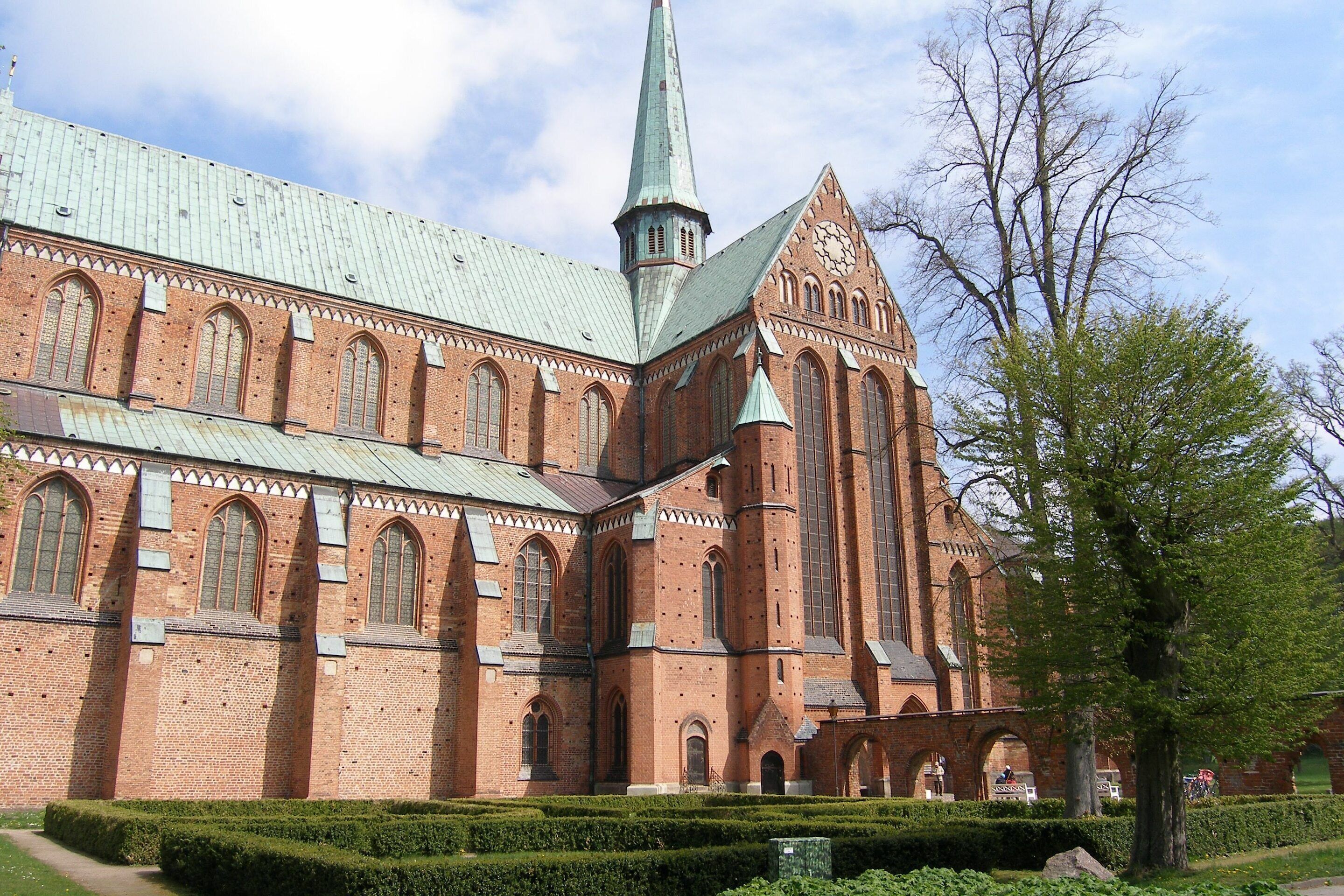 Ein großes Backsteingebäude mit einem markanten Turm und Rundbogenfenstern.