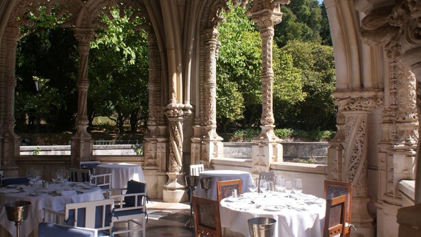 An outdoor dining area with stone arches, tables set for dining, and a view of greenery and trees in the background. - Spacious Holiday Home on Estate Near Covas (Tábua)