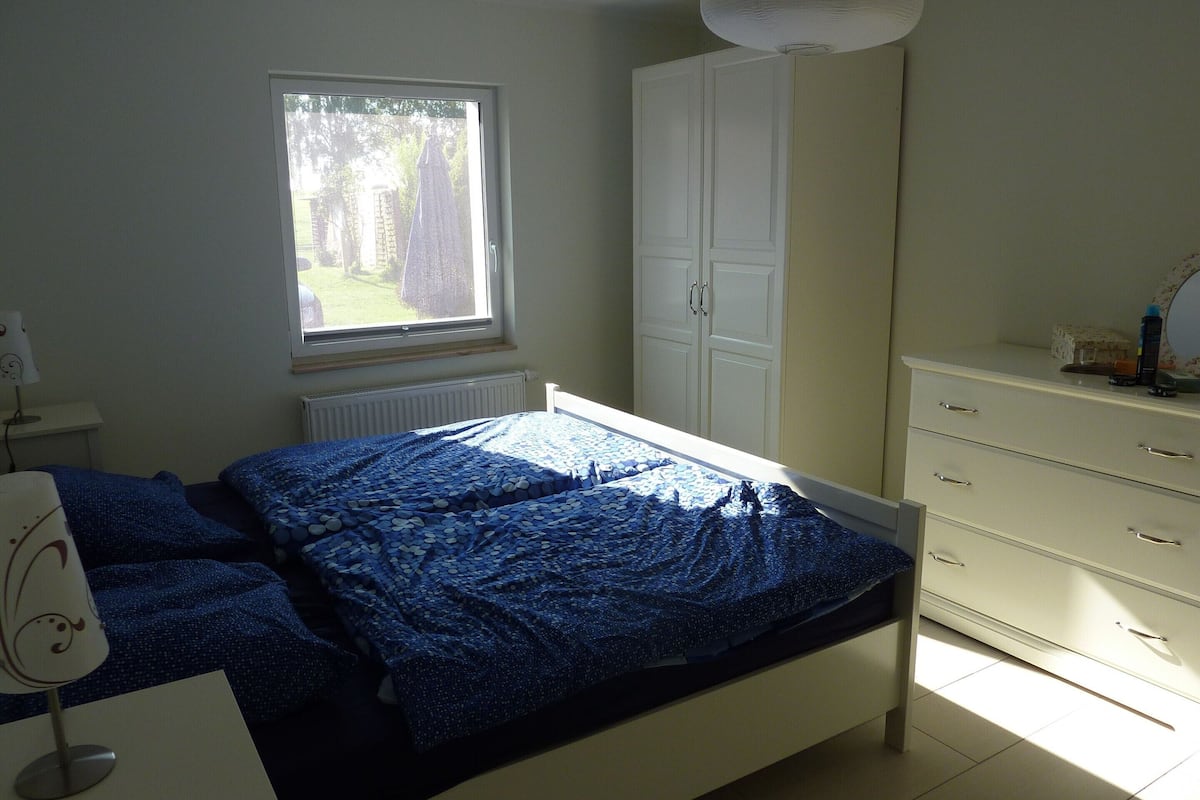 Une chambre à coucher avec un lit, une fenêtre, une armoire et une commode.