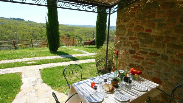 An outdoor dining area with a stone wall, a table set for two, and a view of a mountainous landscape. - Farmhouse With air Conditioning, Private Terrace and Pool (Citta della Pieve)