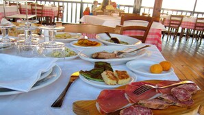 A dining table with various dishes, including meats, bread, and salads. - Charming Residence in the Hills Surrounding La Spezia (Bolano)
