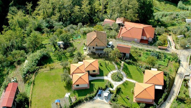 A residential area with multiple houses, each featuring a red-tiled roof and surrounded by lush greenery. - Charming Residence in the Hills Surrounding La Spezia (Bolano)