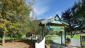 Entrada de un club de golf con un arco verde y un letrero que dice 'Golfclub Lichtenhof'.