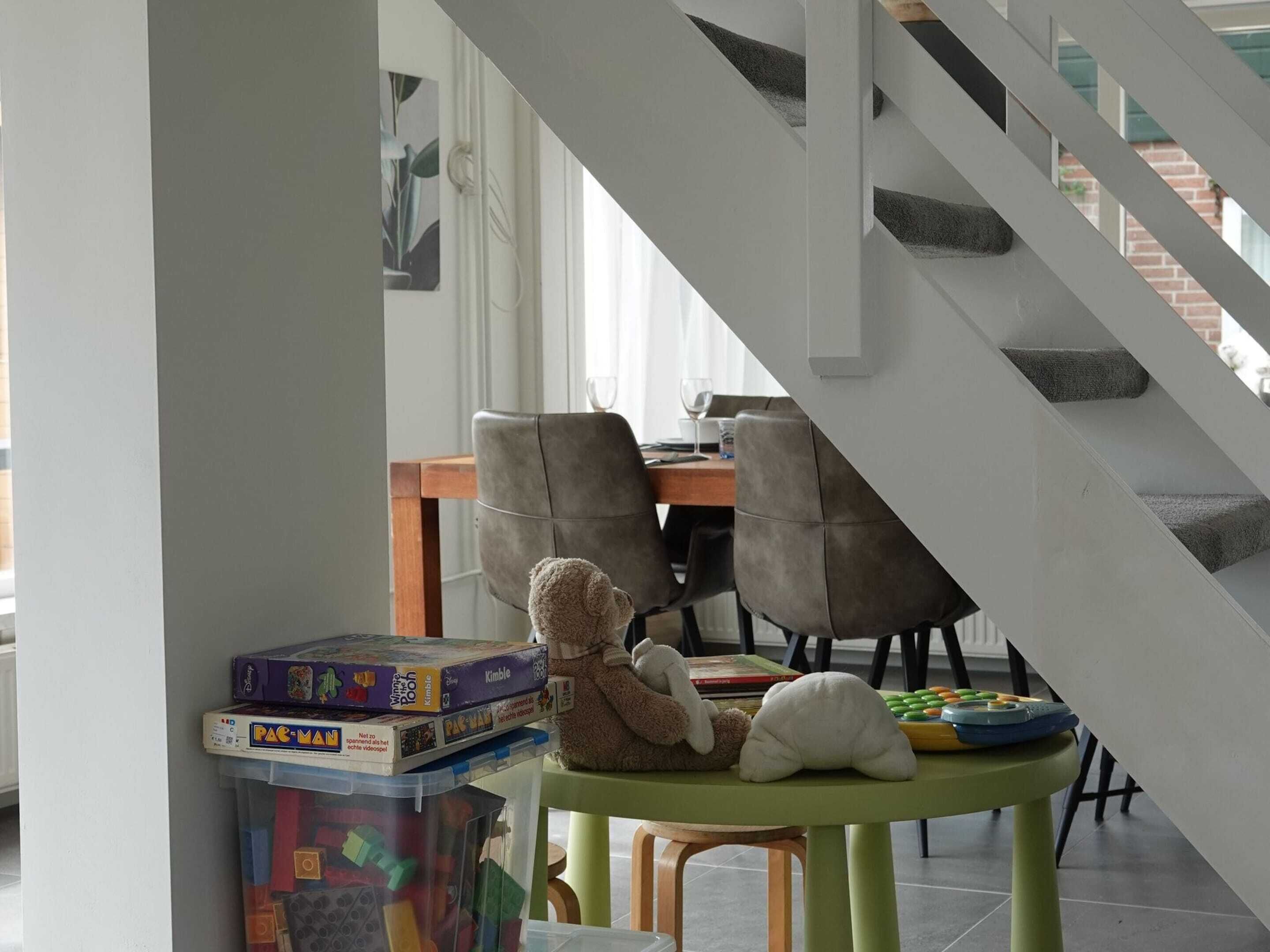 A staircase leading to a dining area with a table and chairs.