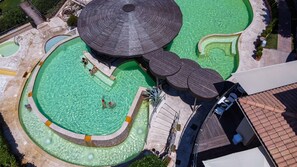 An aerial view of a resort with multiple swimming pools, a large umbrella structure, and a covered seating area. - Gorgeous Holiday Home in Sorano With Swimming Pool (Sorano)