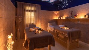 A spa room with two massage tables, candles, and decorative items on shelves. - Gorgeous Holiday Home in Sorano With Swimming Pool (Sorano)