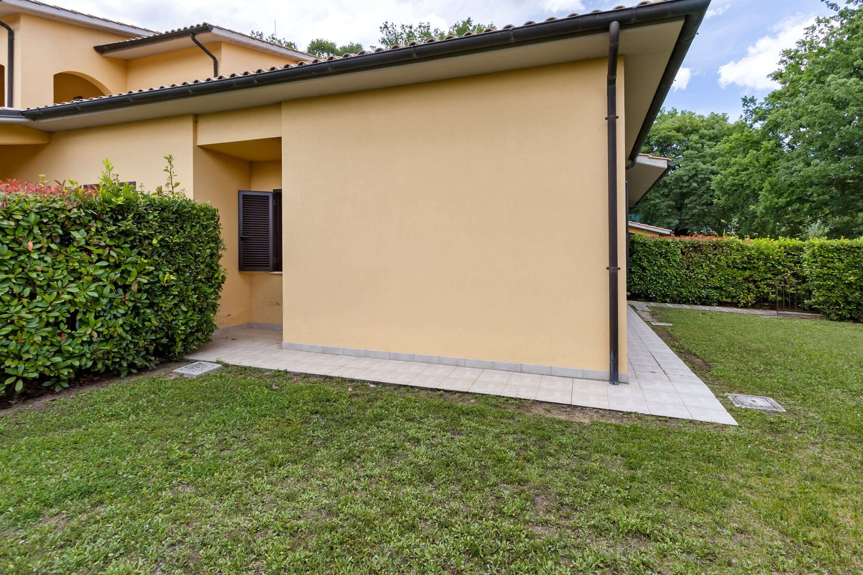 A modern building with a flat roof, a small entrance, and a well-maintained lawn.