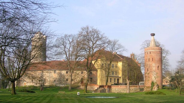 A historic building with a tower, surrounded by a well-maintained lawn and trees. - Holiday Home in Idyllic Ziesar Near the Natuurpark (Ziesar)