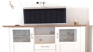 A white cabinet with a flat-screen TV on top, glass-fronted cabinets, and a wooden countertop. - Holiday Home in Idyllic Ziesar Near the Natuurpark (Ziesar)
