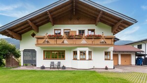 A two-story chalet with a wooden balcony, large windows, and a well-maintained lawn. - Quietly-located Apartment Near the Center of Radstadt (Radstadt)