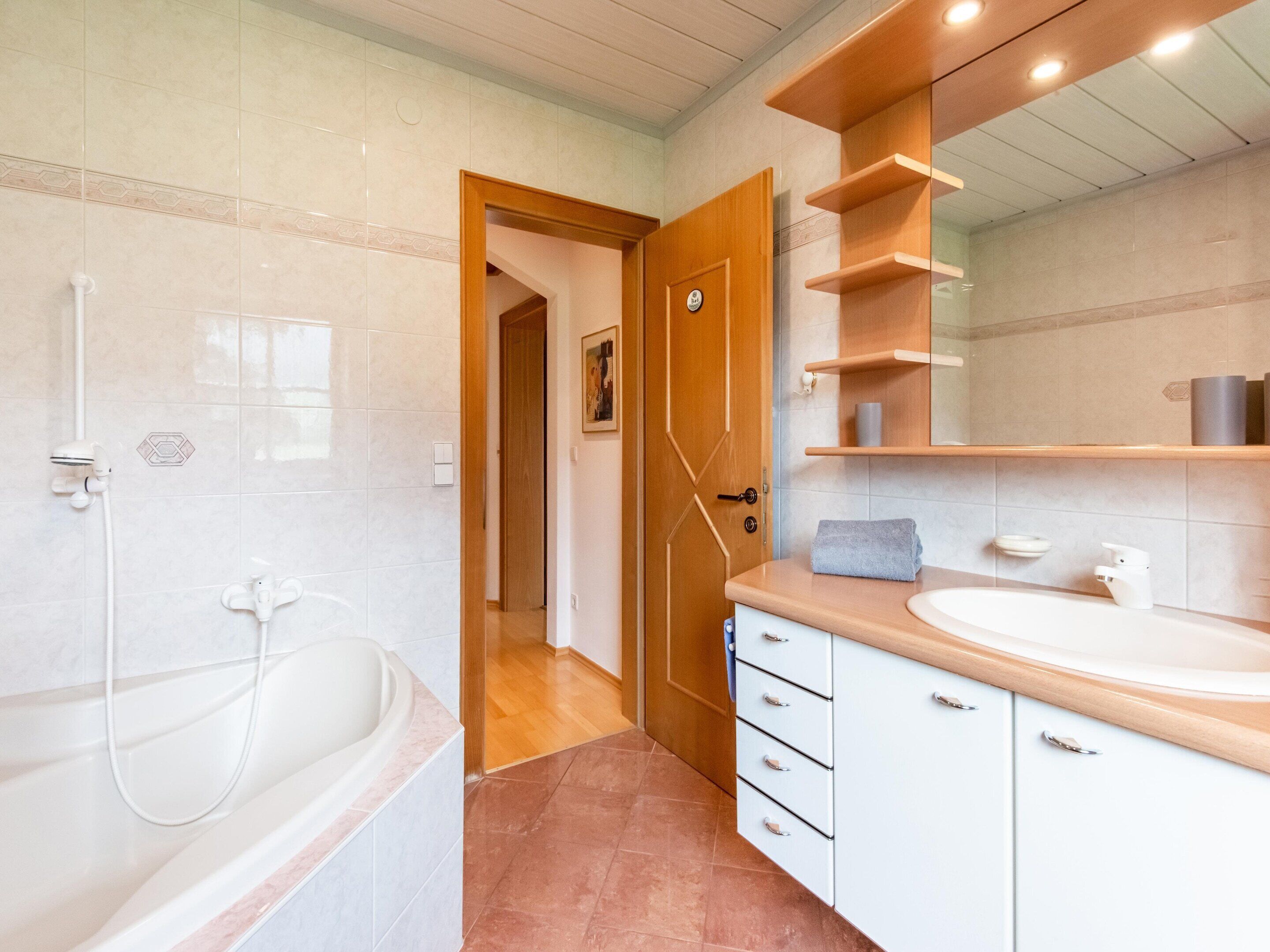 Een moderne badkamer met een bad, een wastafel en een spiegel.