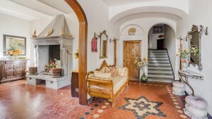Une pièce spacieuse avec un grand lit, une cheminée et un escalier menant à un autre niveau.
