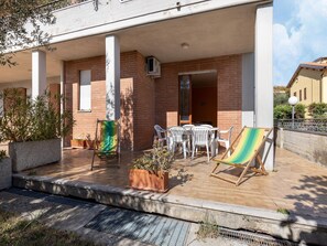 A covered outdoor patio with a table and chairs, potted plants, and a hammock. - Cozy Apartment With Swimming Pool and gym on Lake Trasimeno (Tuoro sul Trasimeno)
