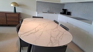 A modern kitchen with a marble countertop, a built-in sink, and a coffee maker. - Modern Apartment in Oostende With Terrace (Ostend)
