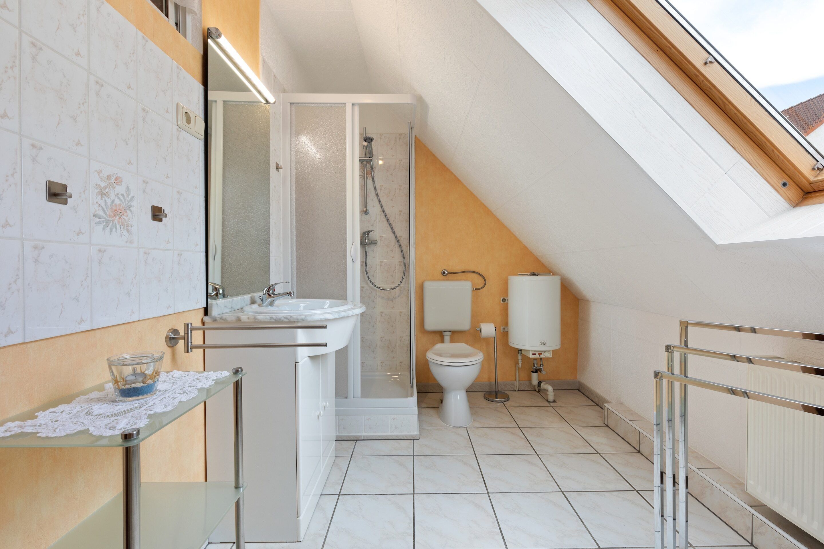 A modern bathroom with a shower, toilet, and sink.
